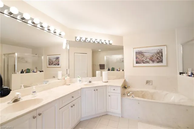 a spacious bathroom with a double vanity sink mirror and bathtub