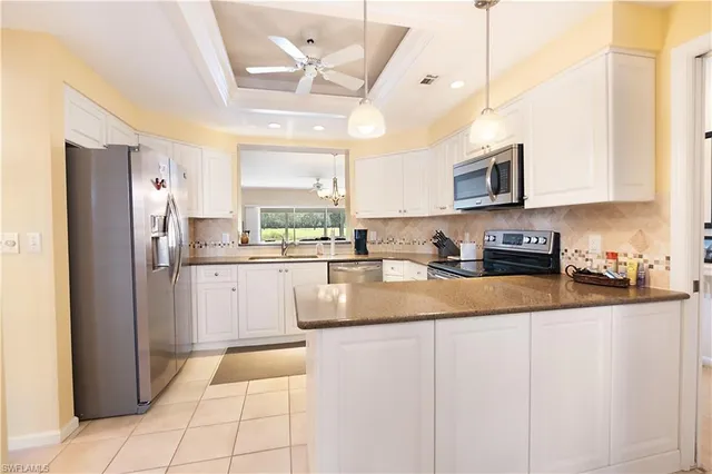 a kitchen with stainless steel appliances granite countertop a refrigerator a stove and a sink