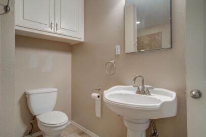 2601 33rd Street, Unit REAR Lubbock, TX 79410 - Photo 13 of 16 a bathroom with a toilet sink and mirror