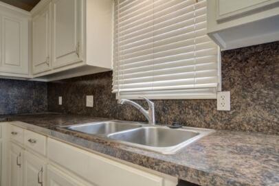 2601 33rd Street, Unit REAR Lubbock, TX 79410 - Photo 6 of 16 a kitchen with granite countertop a sink and a window