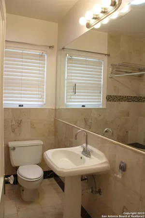 a bathroom with a sink a toilet and mirror