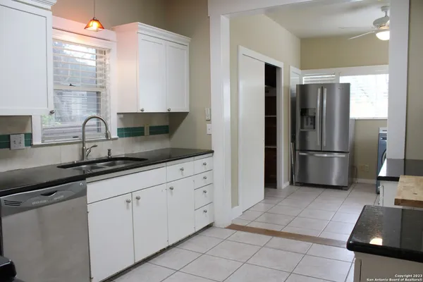 a kitchen with stainless steel appliances granite countertop a refrigerator and a sink