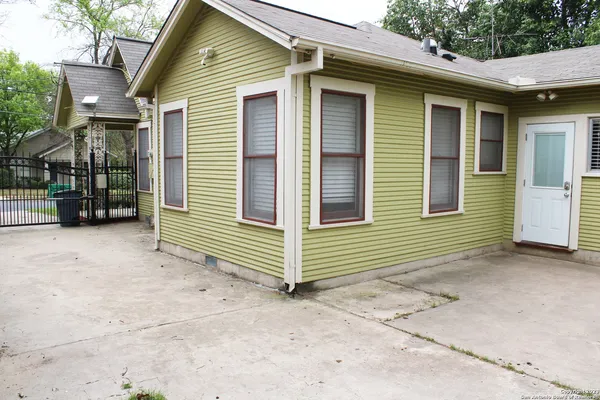 a view of a house with a yard and parking space