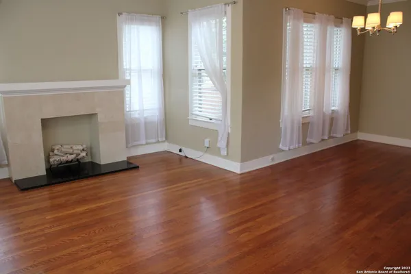 an empty room with wooden floor and a fireplace