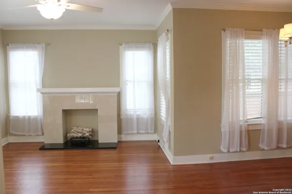 a view of a livingroom with wooden floor and a fireplace