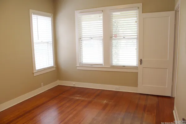 a view of a room with wooden floor and a window