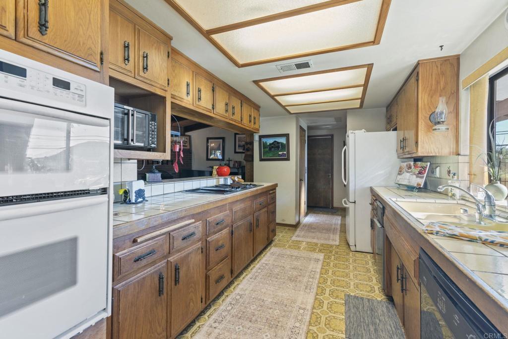 3414 Royal Road Vista, CA 92084 - Photo 16 of 48 a large white kitchen with stainless steel appliances granite countertop a stove and a sink