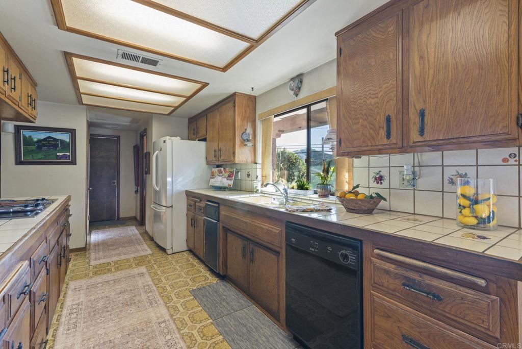 3414 Royal Road Vista, CA 92084 - Photo 17 of 48 a kitchen with a sink stove and cabinets