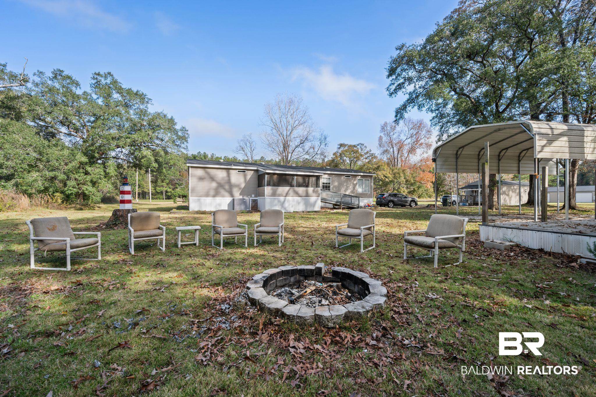 9382 D'Olive Street Bay Minette, AL 36507 - Photo 26 of 27 View of yard featuring an outdoor fire pit and a carport