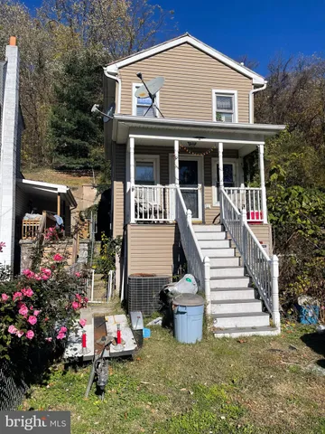 a front view of a house with a porch and garden
