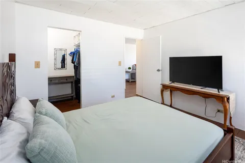 a bedroom with a bed and a flat screen tv