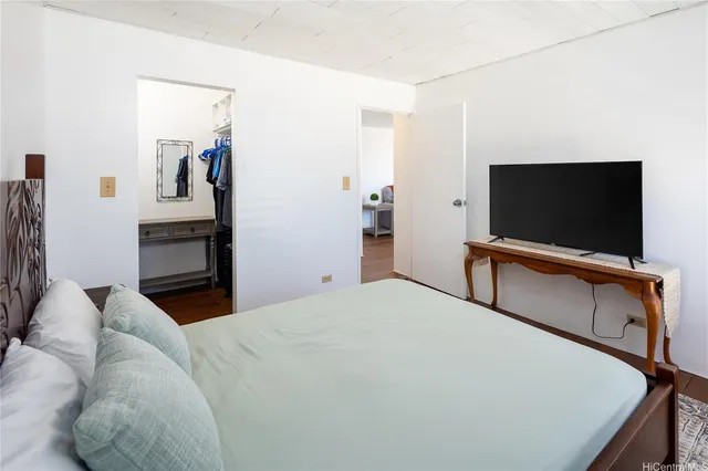 a bedroom with a bed and a flat screen tv