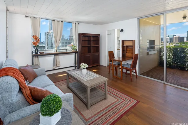 a living room with furniture a desk and chair with wooden floor