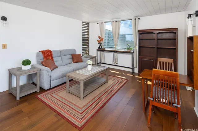 a living room with furniture a rug and a window