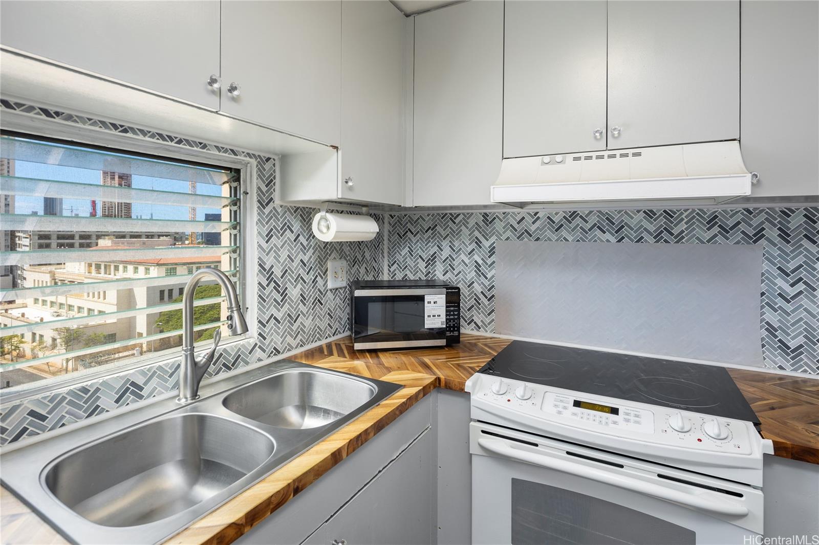785 Kinau Street, Unit 804 Honolulu, HI 96813 - Photo 9 of 16 a kitchen with a sink and a stove top oven
