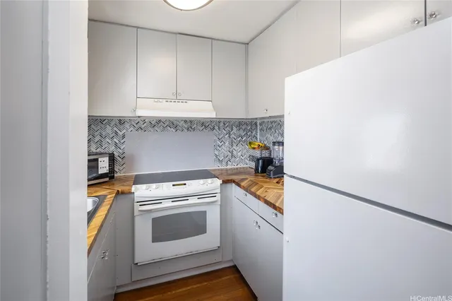 a kitchen with a stove and a white cabinet