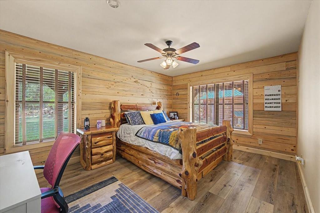 2789 Hanging Tree Road Bowie, TX 76230 - Photo 25 of 40 Wood-finish flooring, wood-paneled walls, and a ceiling fan with integrated lighting