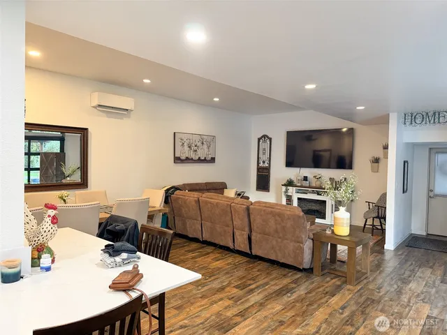 a living room with furniture kitchen view and a flat screen tv