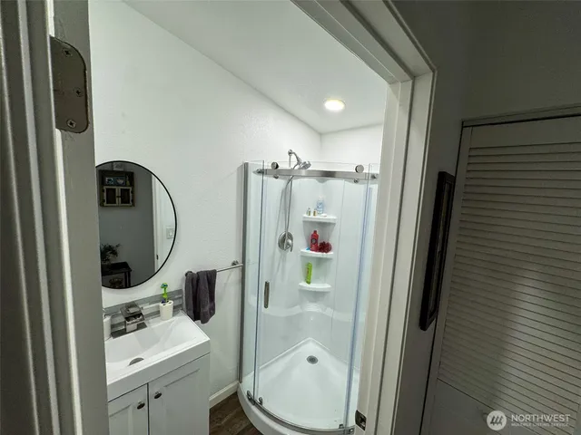 a bathroom with a sink a mirror a toilet and shower