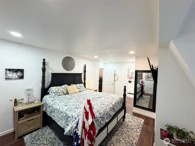 a bedroom with a bed and a dresser with rug