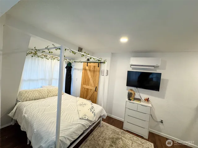 a bedroom with a bed and a flat screen tv