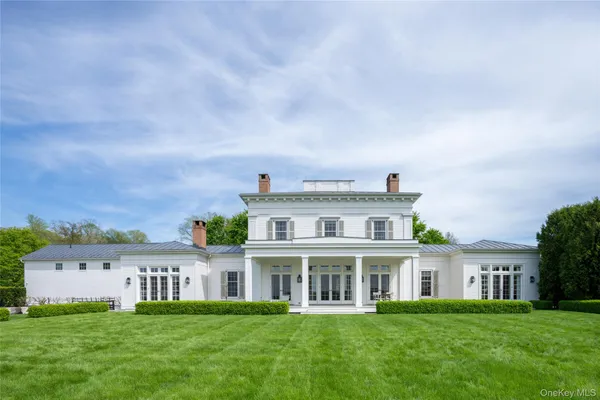 a view of a house with a big yard and large trees