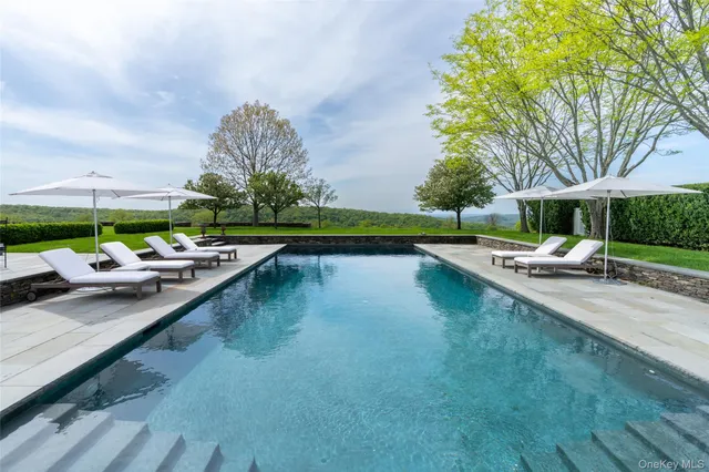 a swimming pool with outdoor seating and yard