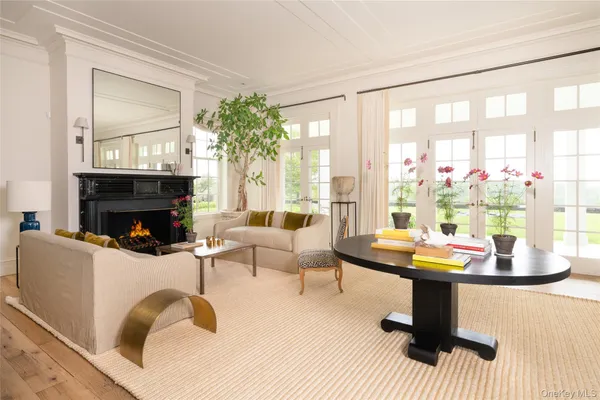 a living room with fireplace furniture and a large window