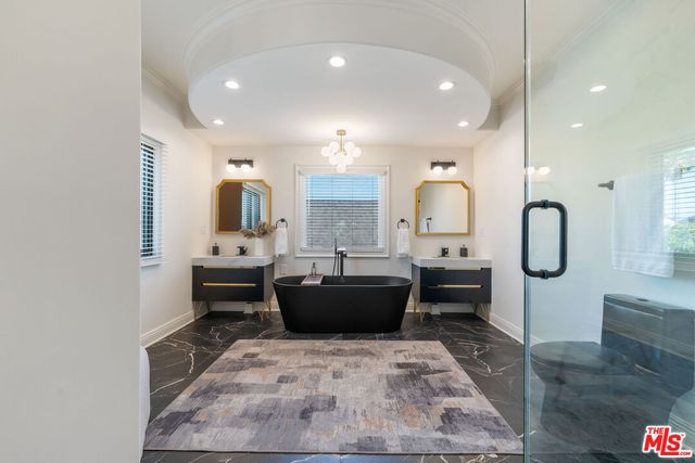 a large bathroom with a tub sink and glass door