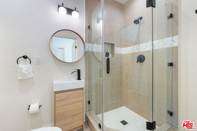 a bathroom with a sink a toilet and shower