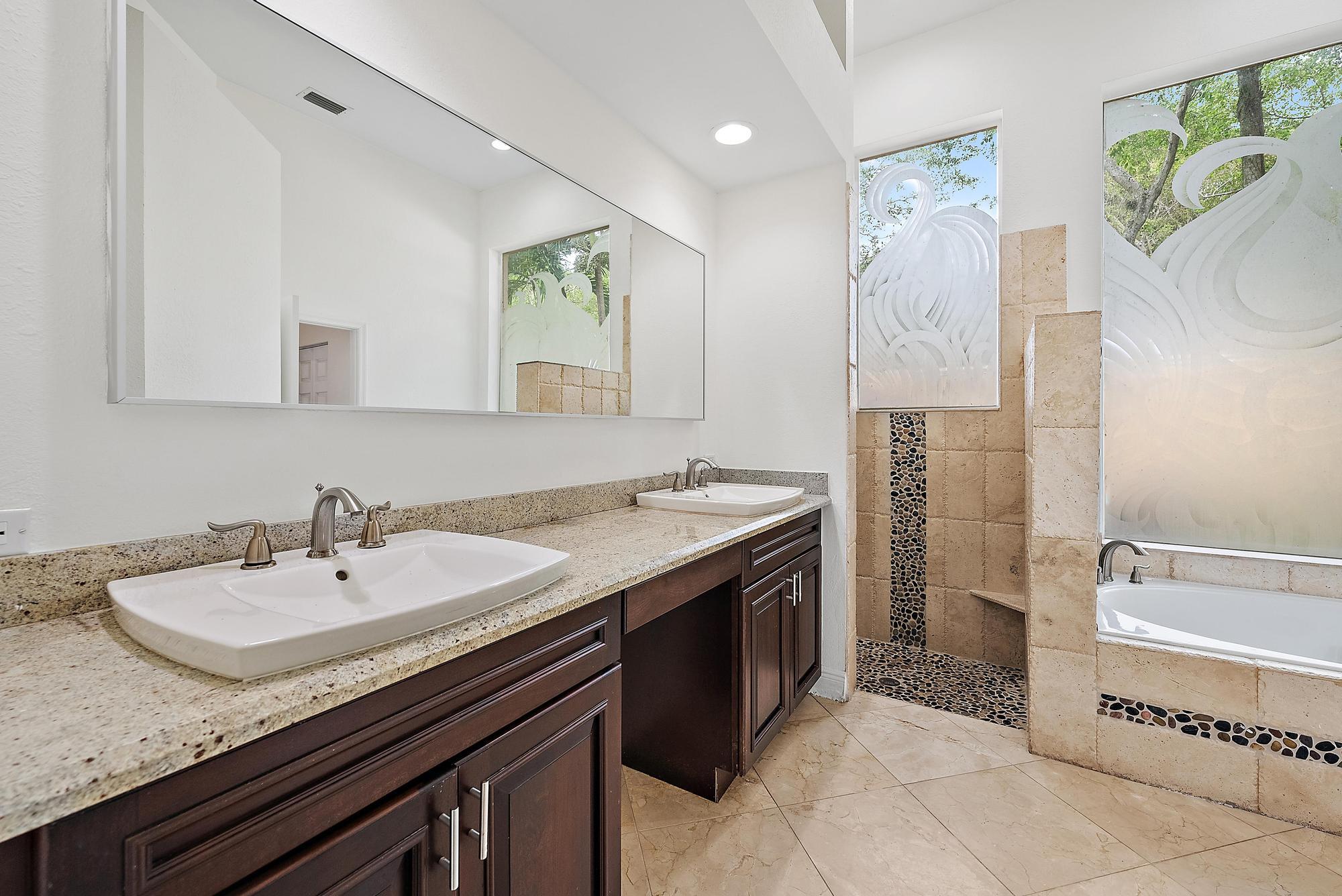 6612 Northwest 23rd Terrace Boca Raton, FL 33496 - Photo 14 of 20 a spacious bathroom with a granite countertop sink and a mirror