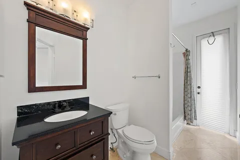a bathroom with a sink a toilet and a mirror