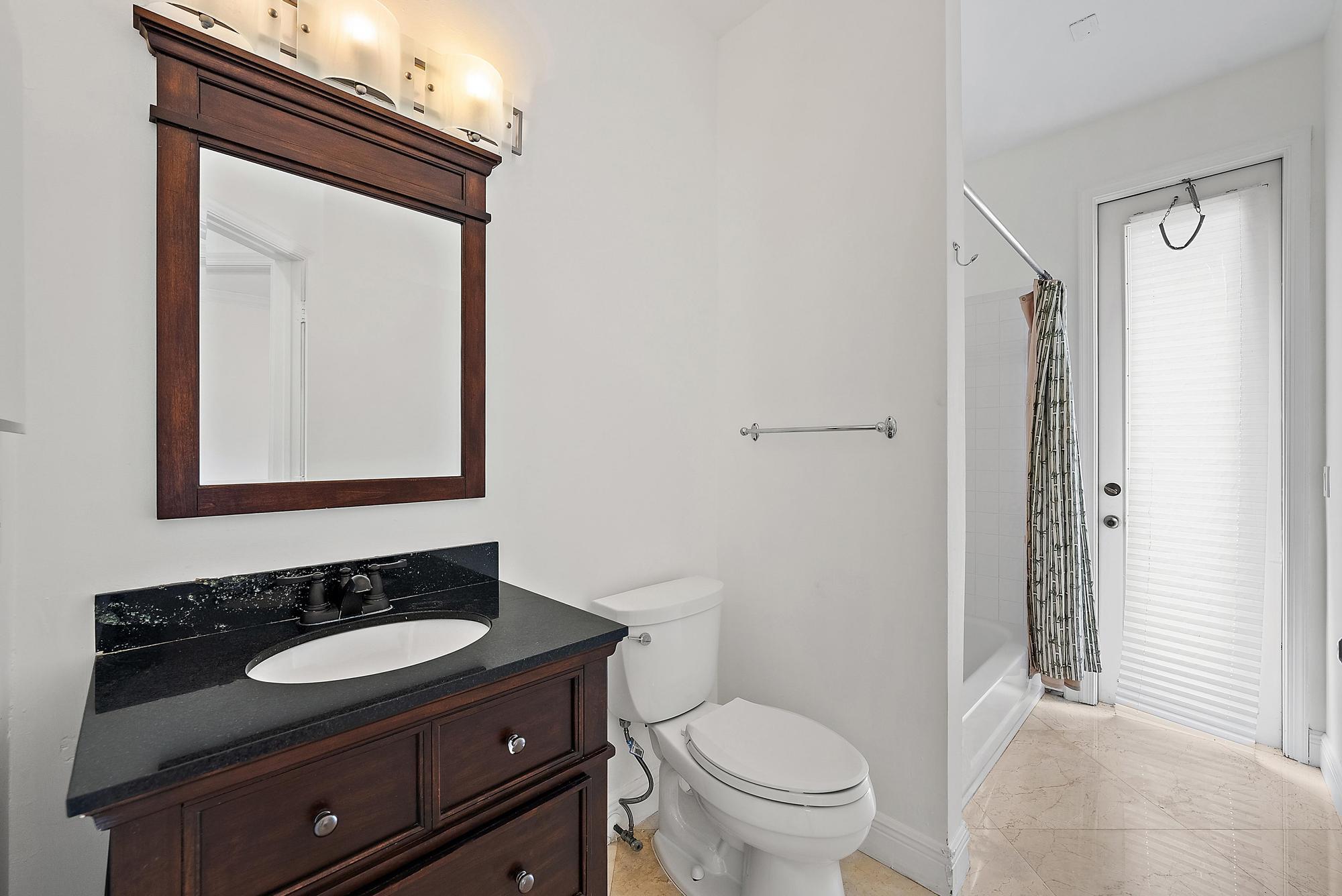 6612 Northwest 23rd Terrace Boca Raton, FL 33496 - Photo 16 of 20 a bathroom with a sink a toilet and a mirror