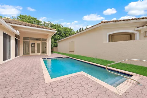 a view of an house with backyard and swimming pool