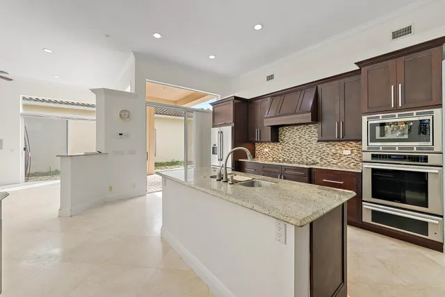 a kitchen with stainless steel appliances granite countertop a sink and a stove