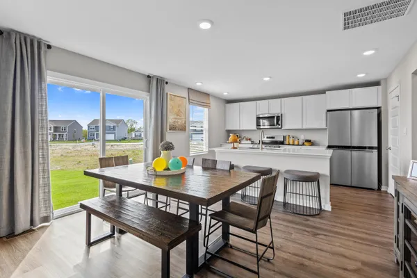a kitchen with a table chairs refrigerator and cabinets