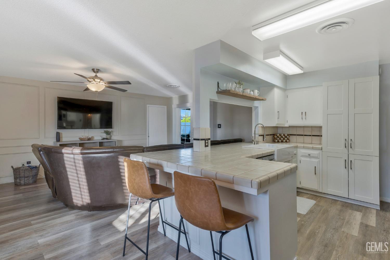 Undisclosed Address Bakersfield, CA 93306 - Photo 11 of 38 a kitchen with stainless steel appliances granite countertop a stove top oven a sink dishwasher a dining table and chairs with wooden floor