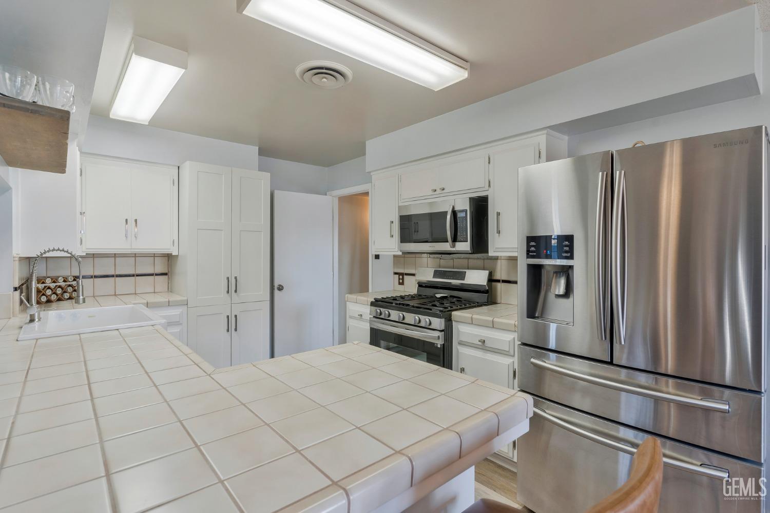 Undisclosed Address Bakersfield, CA 93306 - Photo 16 of 38 a kitchen with stainless steel appliances a refrigerator sink and microwave