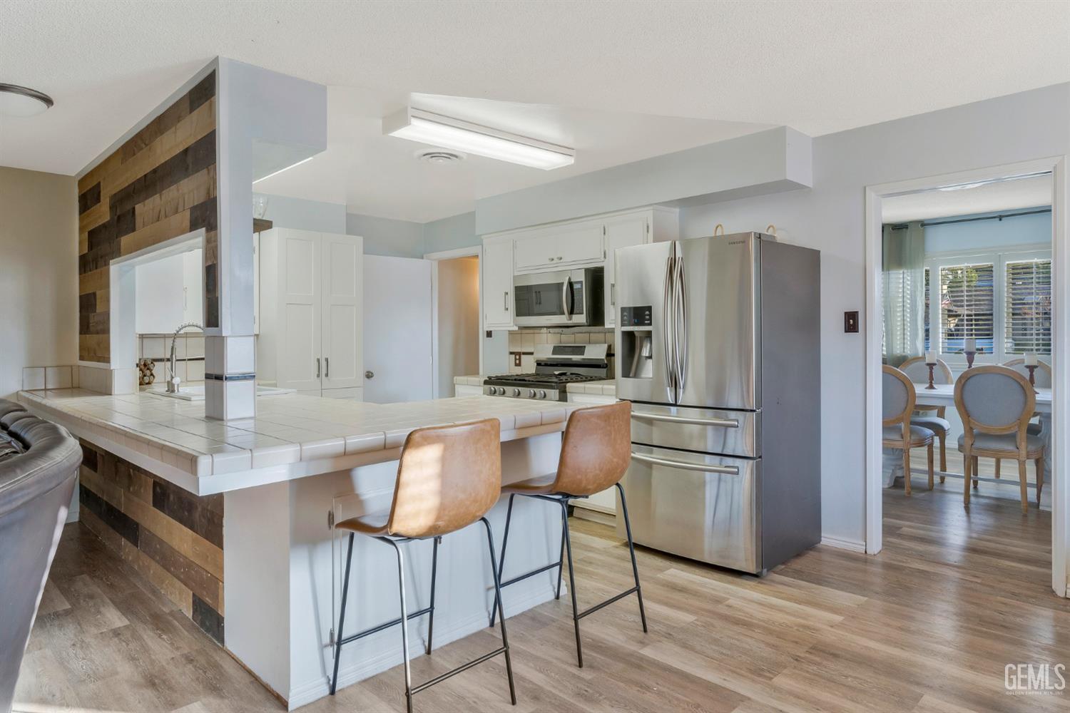 Undisclosed Address Bakersfield, CA 93306 - Photo 10 of 38 a kitchen with stainless steel appliances a refrigerator a stove a sink a dining table and chairs