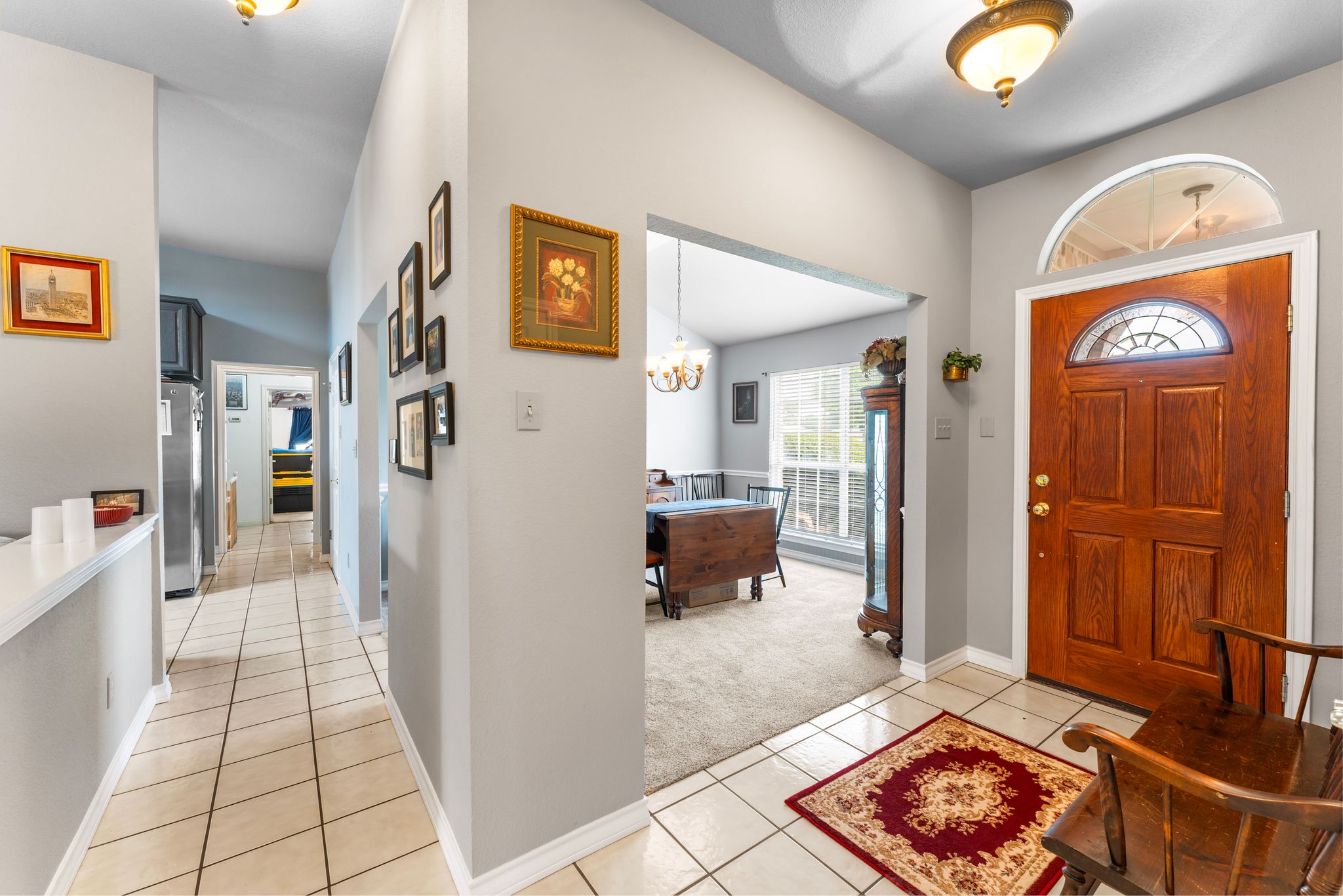 221 Breakaway Road Cedar Park, TX 78613 - Photo 20 of 39 Entrance foyer with light carpet, light tile patterned floors, baseboards, and a chandelier