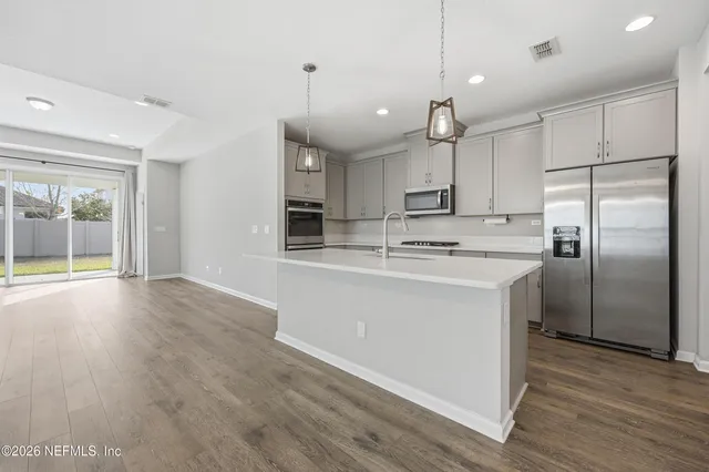 a kitchen with kitchen island white cabinets and refrigerator