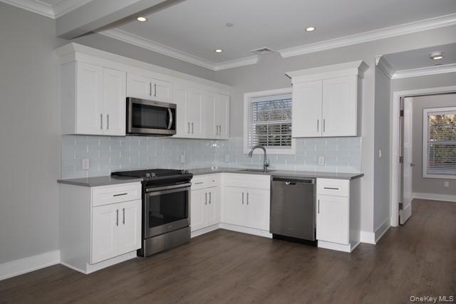 262 Indian Head Road, Unit 211 Kings Park, NY 11754 - Photo 3 of 8 a kitchen with stainless steel appliances granite countertop a stove top oven a sink dishwasher and a microwave oven with white cabinets