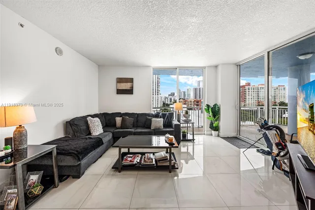a living room with furniture a wooden floor and a flat screen tv