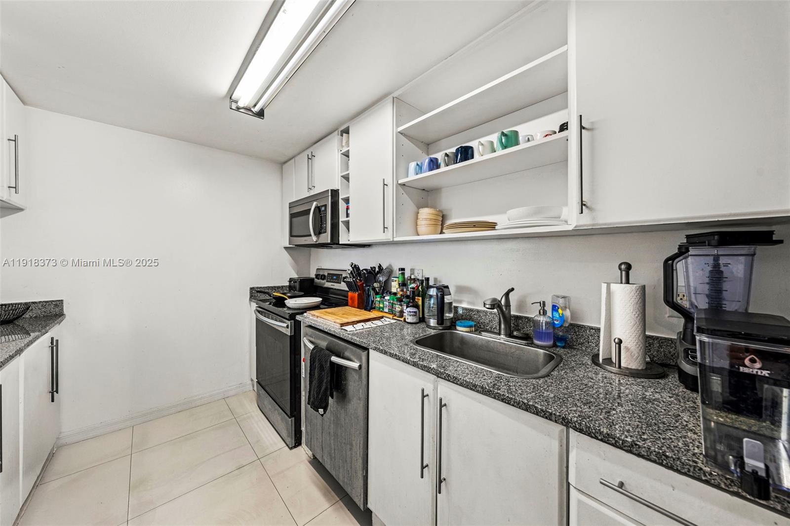 275 Northeast 18th Street, Unit 708 Miami, FL 33132 - Photo 29 of 34 a kitchen with stainless steel appliances granite countertop a sink and cabinets