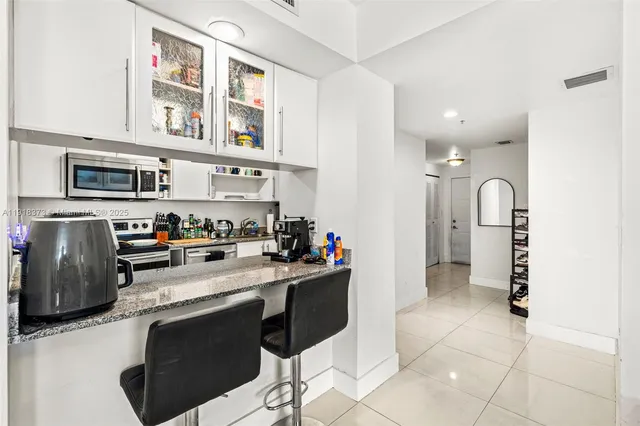 a kitchen with stainless steel appliances a stove refrigerator sink and cabinets