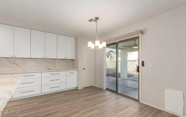 a view of a kitchen with wooden floor and chandelier