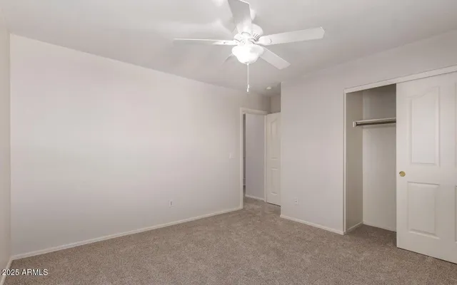 an empty room with a chandelier fan
