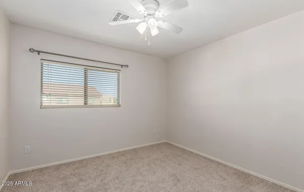 an empty room with a window and a fan