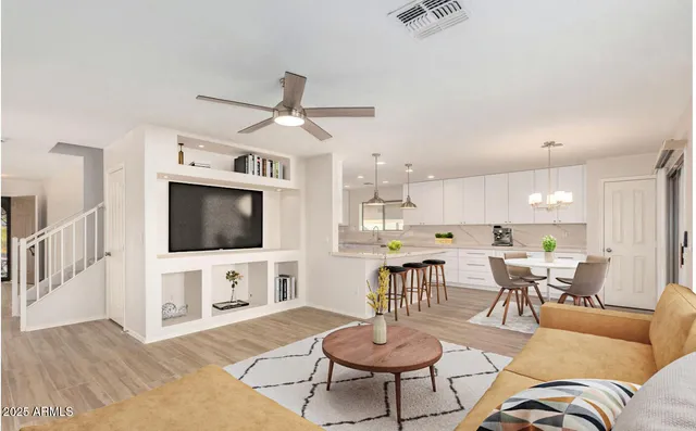 a living room with furniture a flat screen tv and kitchen view