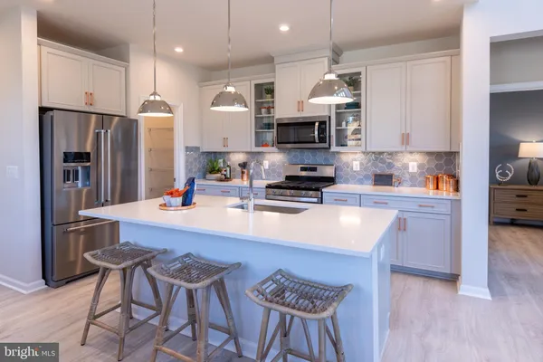 a kitchen with stainless steel appliances granite countertop a sink refrigerator stove microwave and cabinets